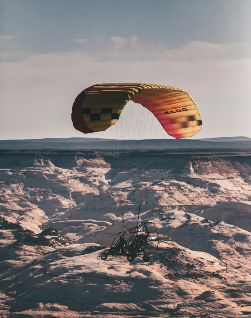motorized paraglider buggy flying above a desert